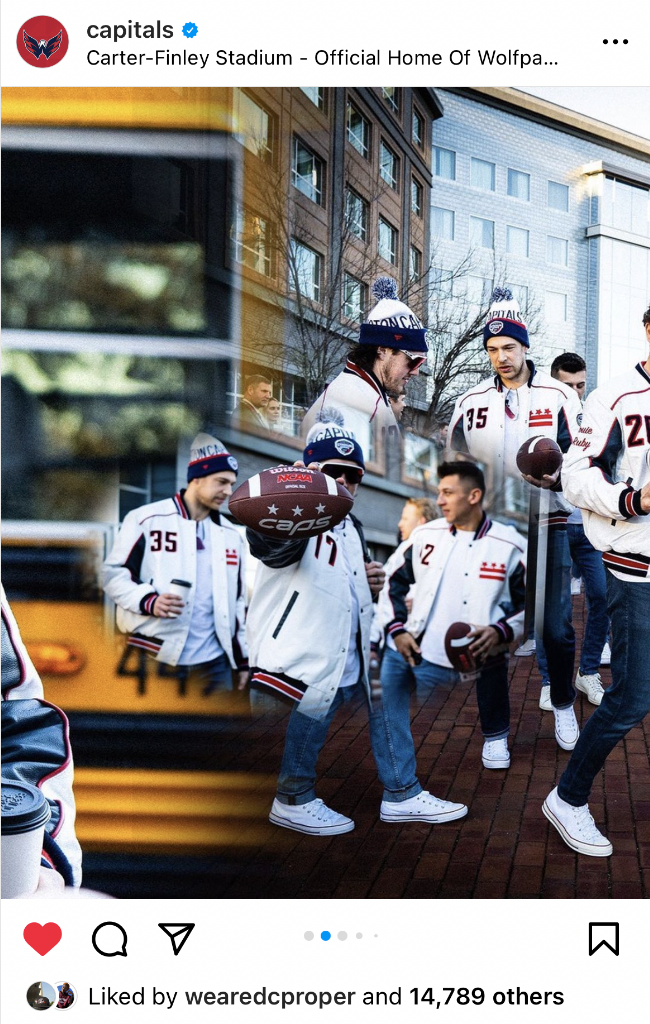 Group of young men wearing Washington Capitals hockey team jackets and hats, gathered outside Carter-Finley Stadium, some holding footballs, with buildings and trees in the background.