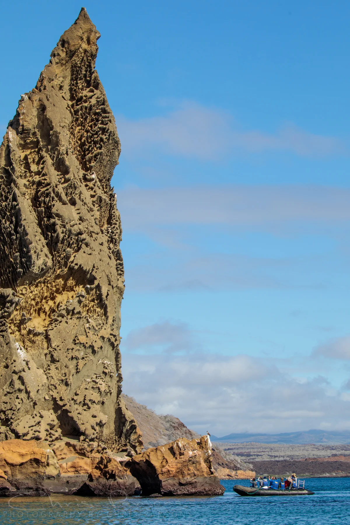 Our group looks for birds and penguins at the base of the iconic Pinnacle Rock.