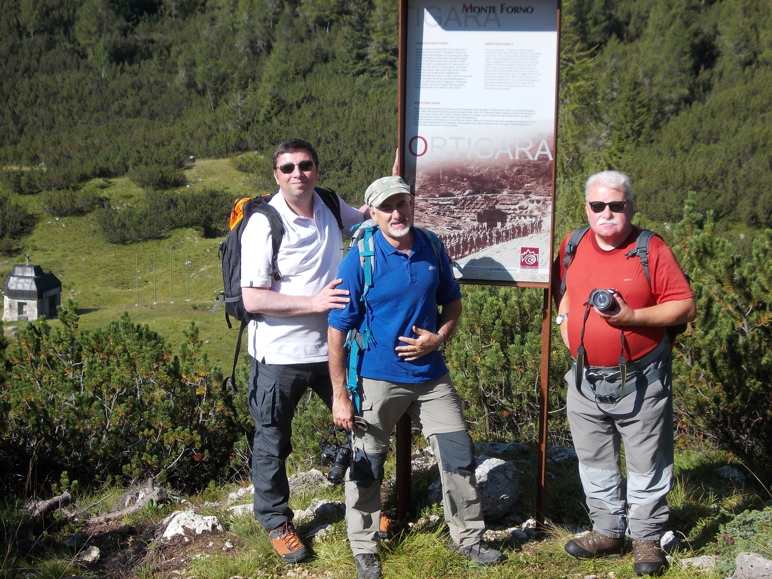 Stefano Aluisini, Ruggero Dal Molin e Sergio Giacomelli alla Fornokapelle di Busa della Pesa M. Forno che, ai piedi del suo Cristo ligneo, ospitava il cimitero del 27° I.R. di Graz