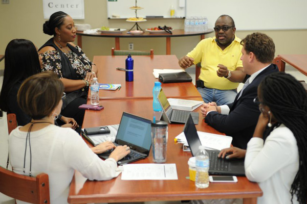 UCF staff and community members met last year to determine if Evans High School - A Community Partnership School met the criteria to become certified. First row, front to back: Amy Ellis, director of the Center for Community Schools; Sarai Antoine, Student Leadership Council vice chair, Kea Cherfrere, Community Council chair and Evans alumna. Second row, front to back: Lakema Massey, Community Partnerships School director, Sulphur Springs YMCA, Jarrad Plante, programs coordinator for the Center for Community Partnerships, and Pastor Frank Thompson.
