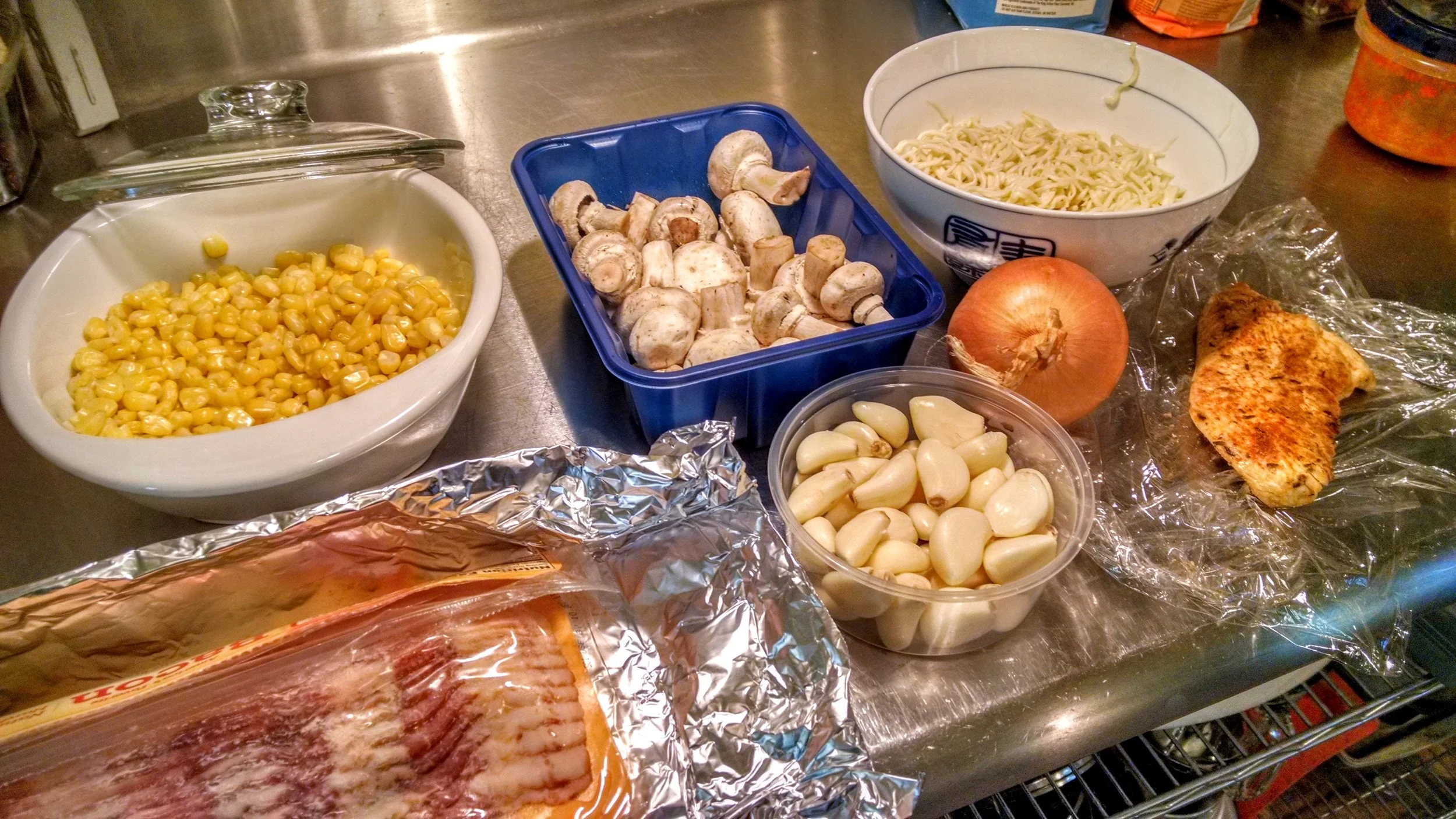 Sweet Corn (from frozen), button mushrooms, homemade pasta, bacon, garlic, onions and roasted chicken breast. Cheddar cheese will be added on top at the end.
