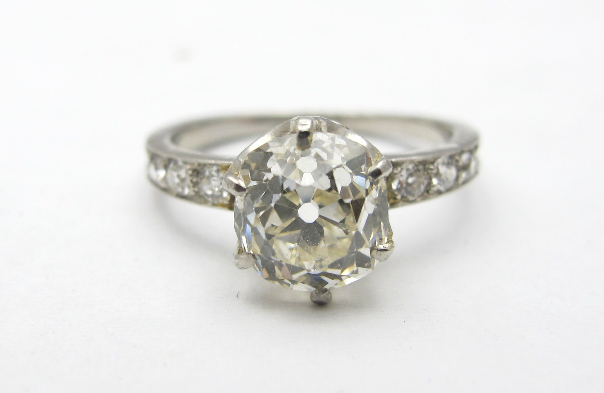 Platinum setting with EGL certified 2.05ct J color, VS2 clarity old mine cut center diamond and old European accent diamonds.