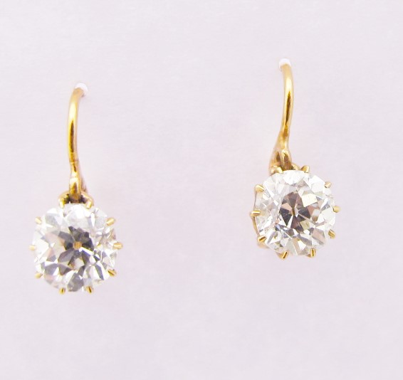 Pair of 1.30ct J/VS2 old mine cut diamonds in rosey 18k yellow gold settings. c. 1900. 