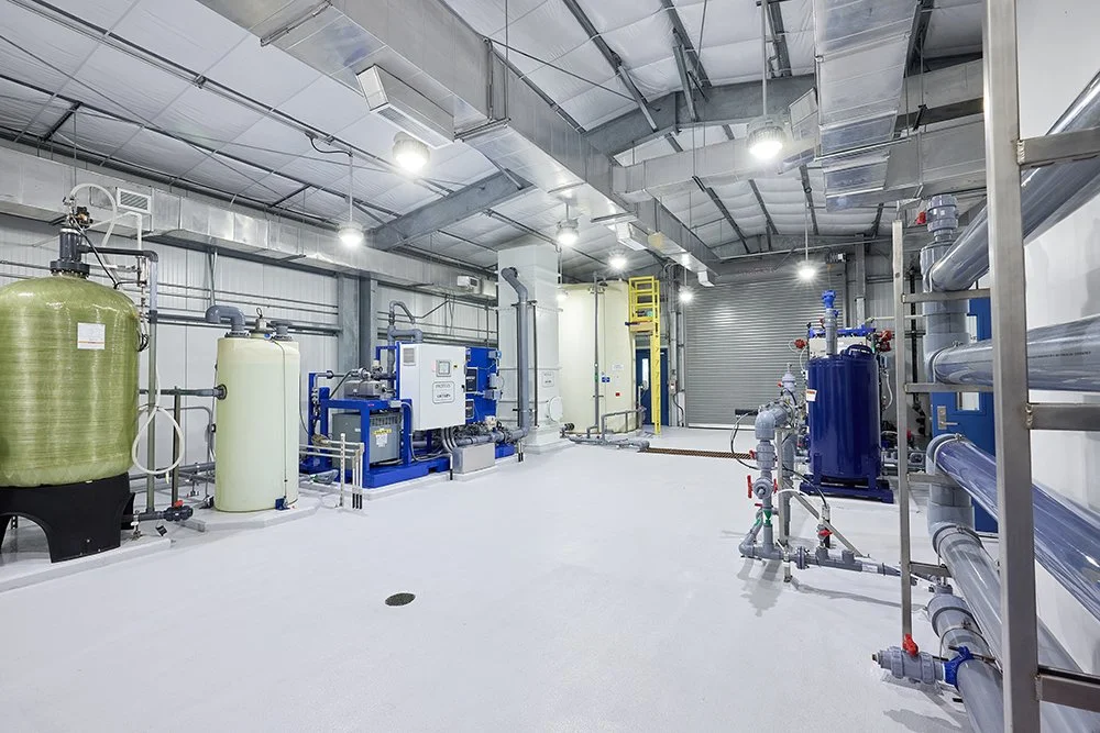 Industrial water treatment or reverse osmosis facility with tanks, pipes, and filtration equipment.