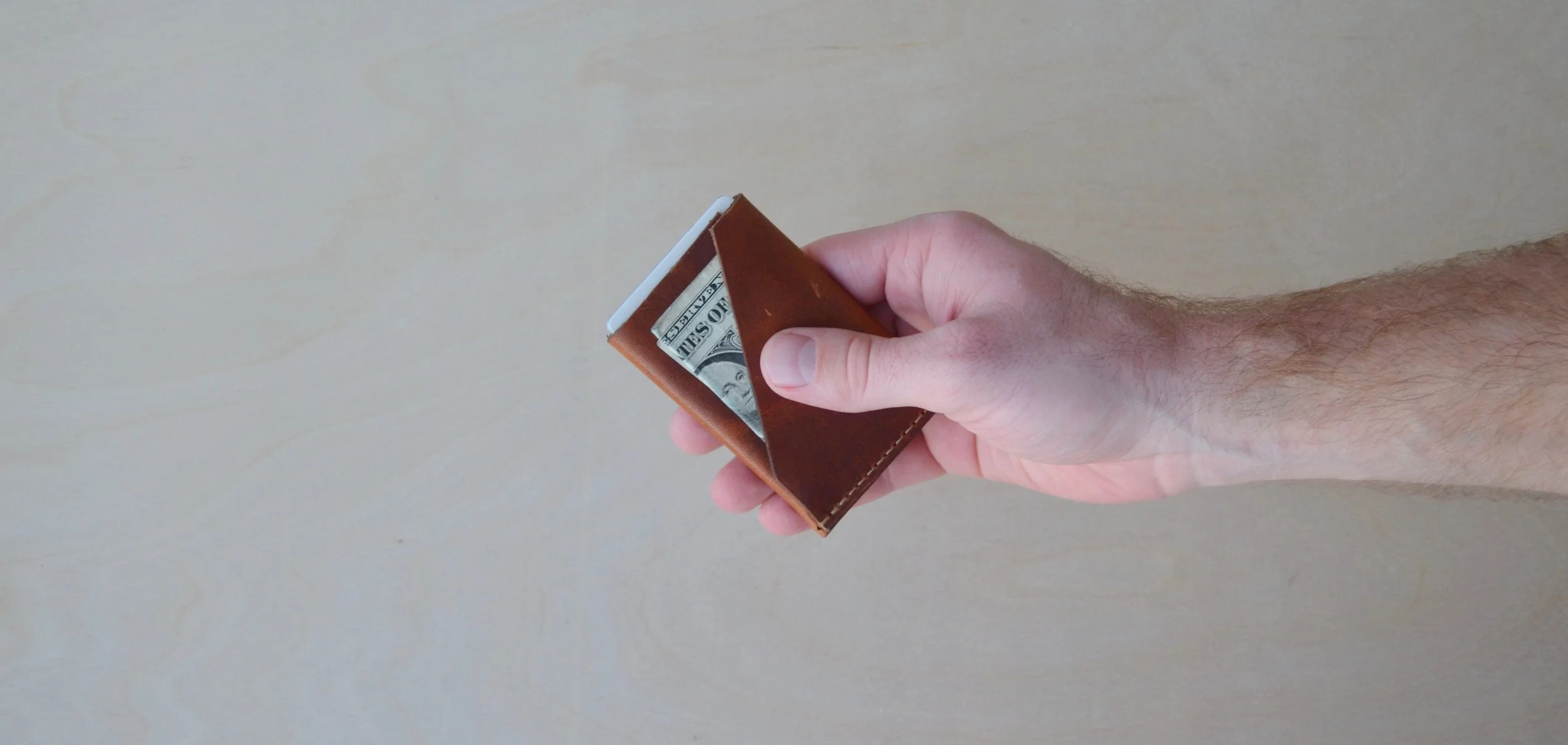  The result is the wrap wallet. Using one piece of leather and wrapping it allows there to be only one stitch while still maintaining a secure place to store your cards and money. 