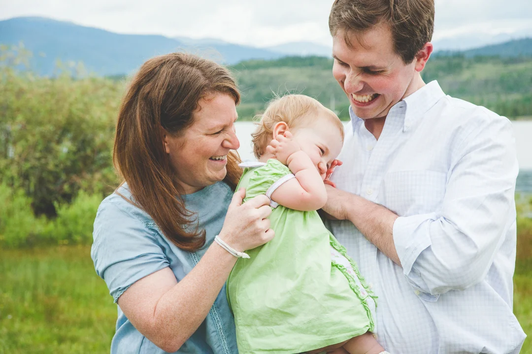 Mom and dad try to tickle some smiles out of their young daughter, who was still sleepy since our family photo session was right in the middle of nap time!