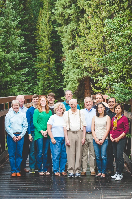 a large family group poses for their family photo on a bridge in the woods at Copper Mountain Resort.