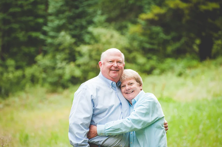 Husband and wife hug each other tight and are all smiles for their family portrait at Copper Mountain.