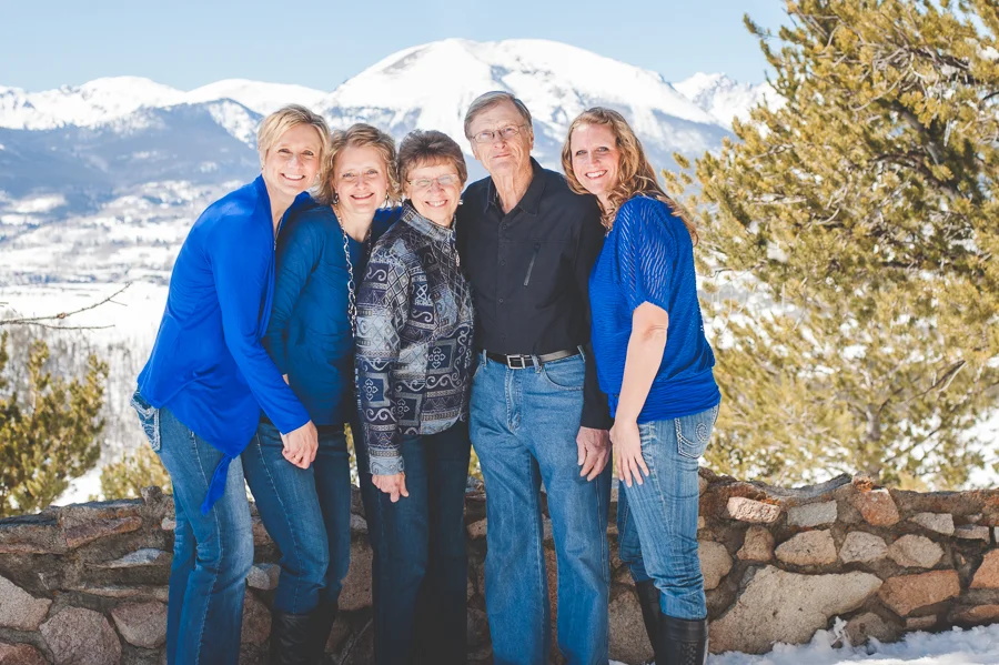 Mom and dad and three daughters - all grown up with children of their own - pose together in a winter family photo session near Breckenridge, Colorado.