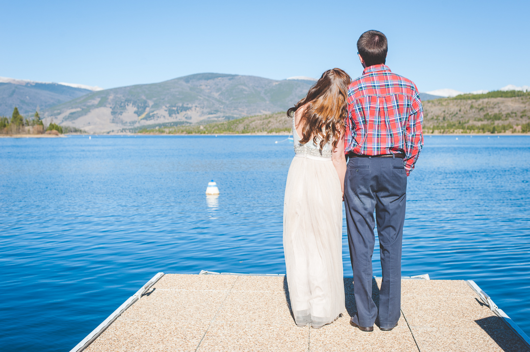 Colorado bride and groom take a moment to look out across the lake and the mountains after their intimate elopement.