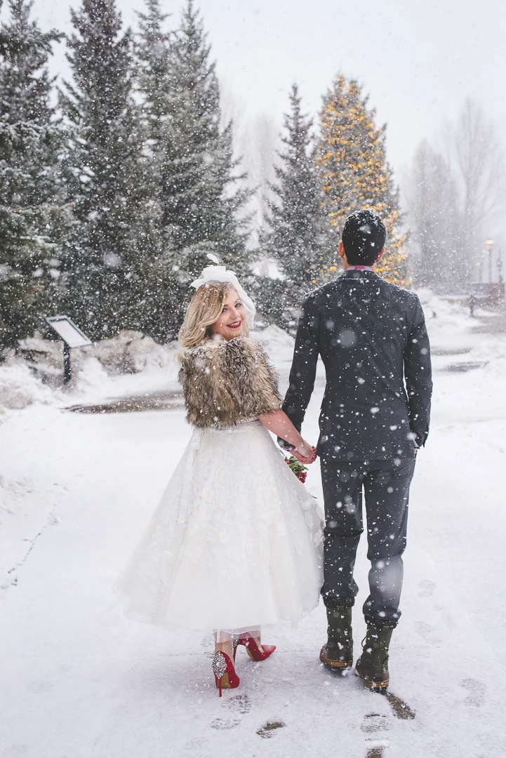 Fur shawl, red lips, red shoes and a perfect tea-length wedding dress complete the bride's look for her destination winter elopement in Breckenridge, Colorado. | Keeping Composure Photography