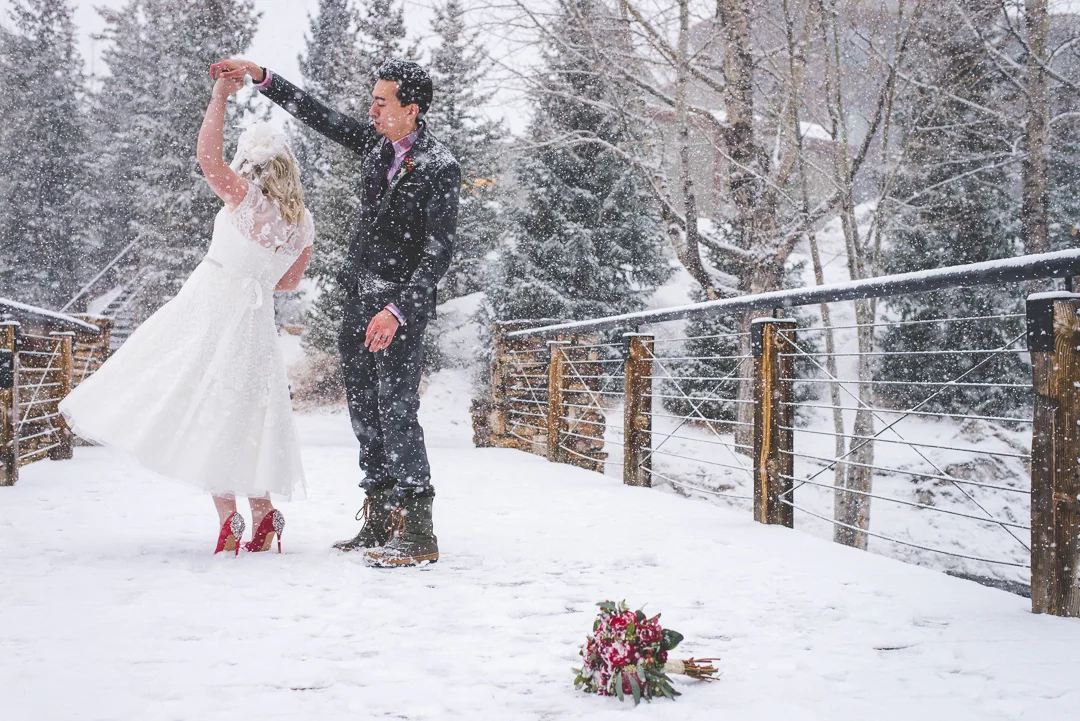When it snows on your wedding day, Dance! Red accents pop on the white snow in this Breckenridge, Colorado elopement. Red nails, red flowers, red shoes and red lips: winter magic. | Keeping Composure Photography