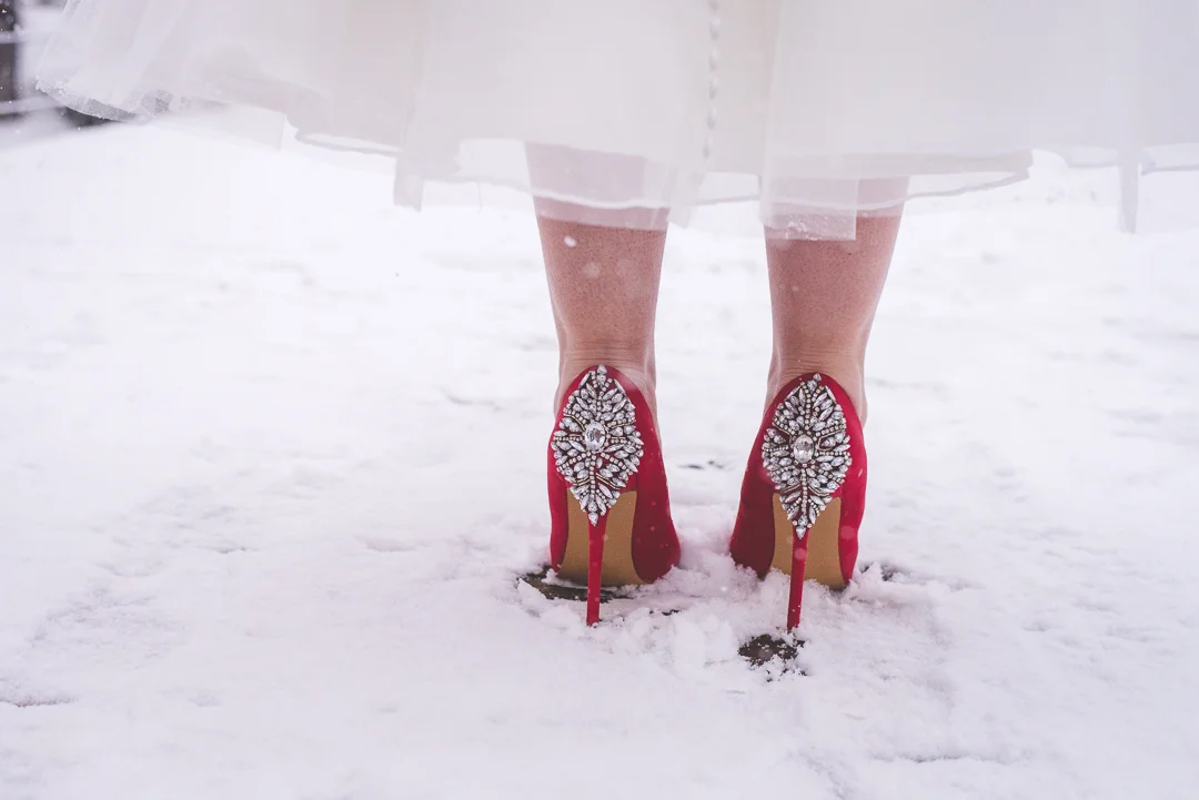 This bride's red accents pop against the falling snow during her winter elopement in Breckenridge, Colorado. | Keeping Composure Photography