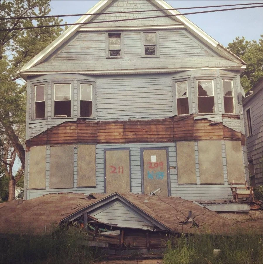 The front porch of a dilapidated house on Brinkman Ave in the City of Buffalo collapses.