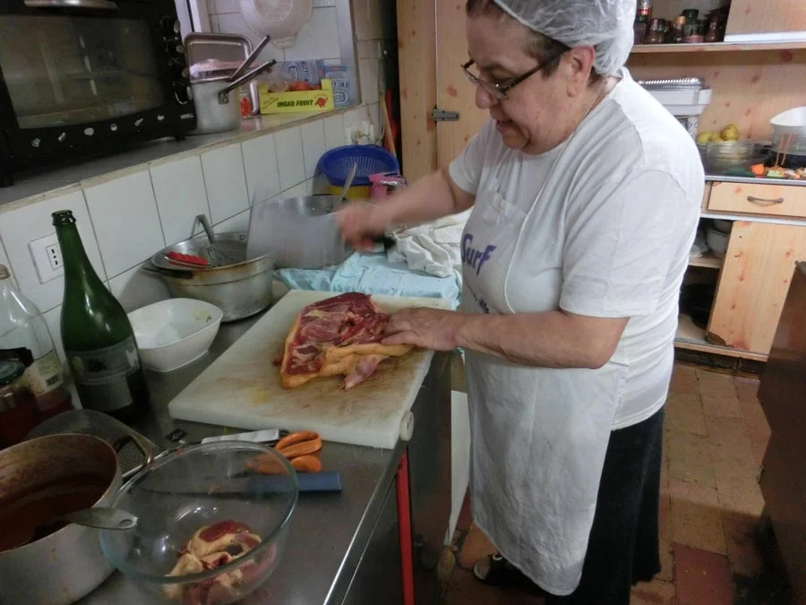 Mirella chops the duck carcass in half. 