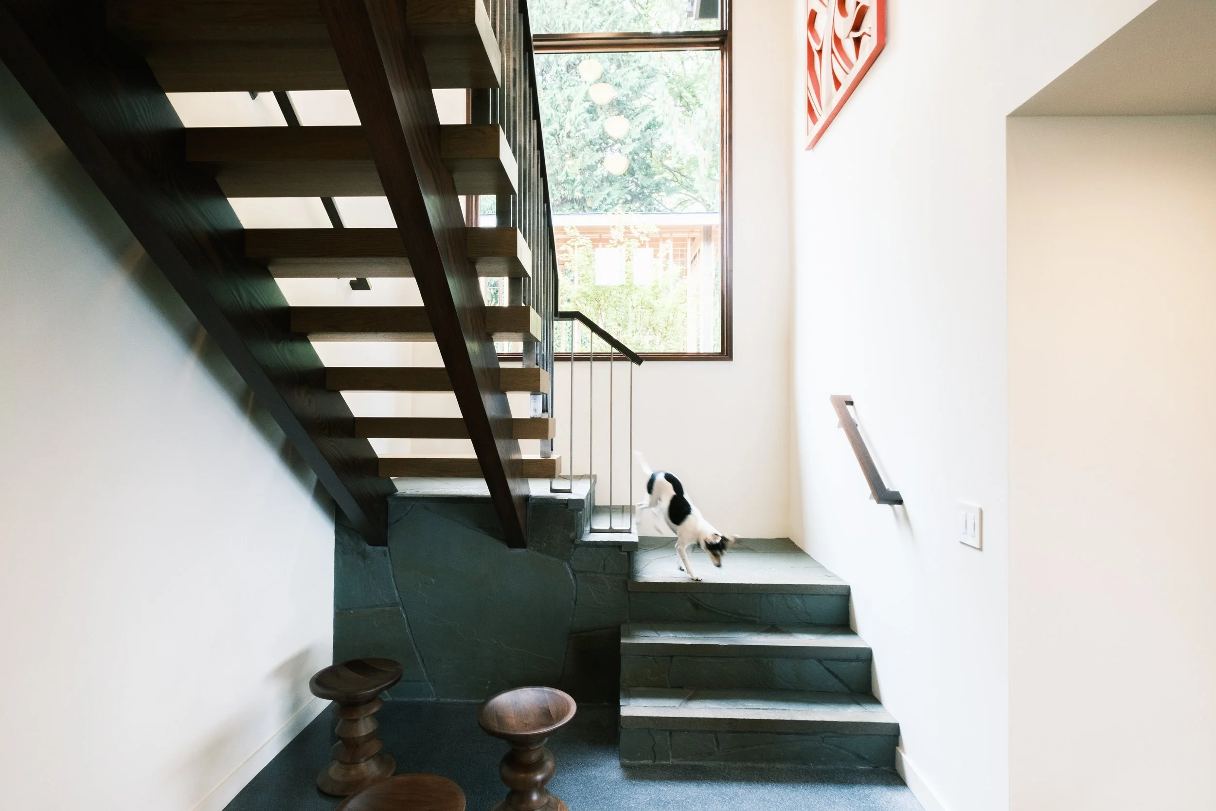 Piano Nobile residential interior with open wood staircase, stone steps, and large window.