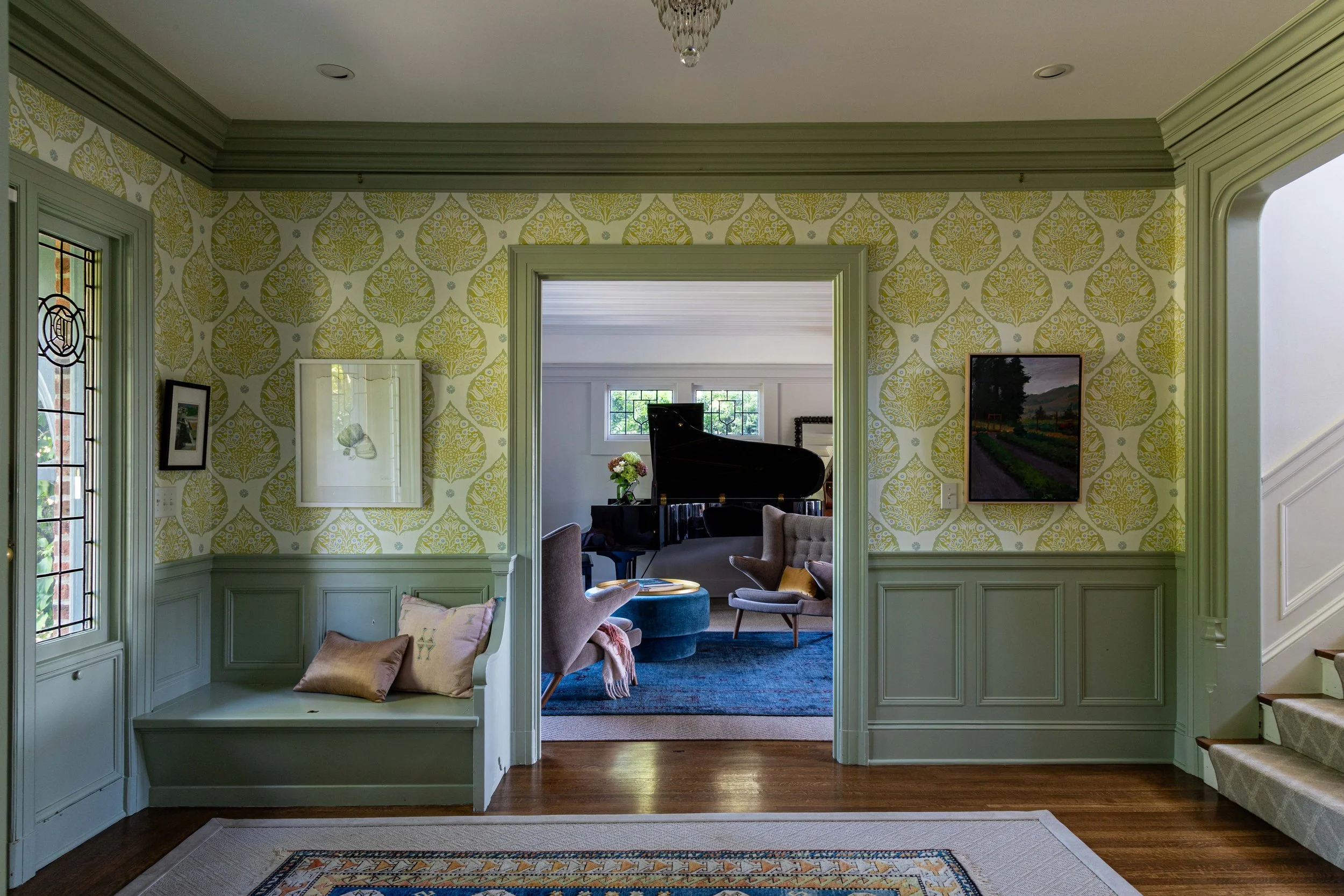 Piano Nobile residential interior with patterned wallpaper, custom millwork, built-in seating, and adjoining living room.