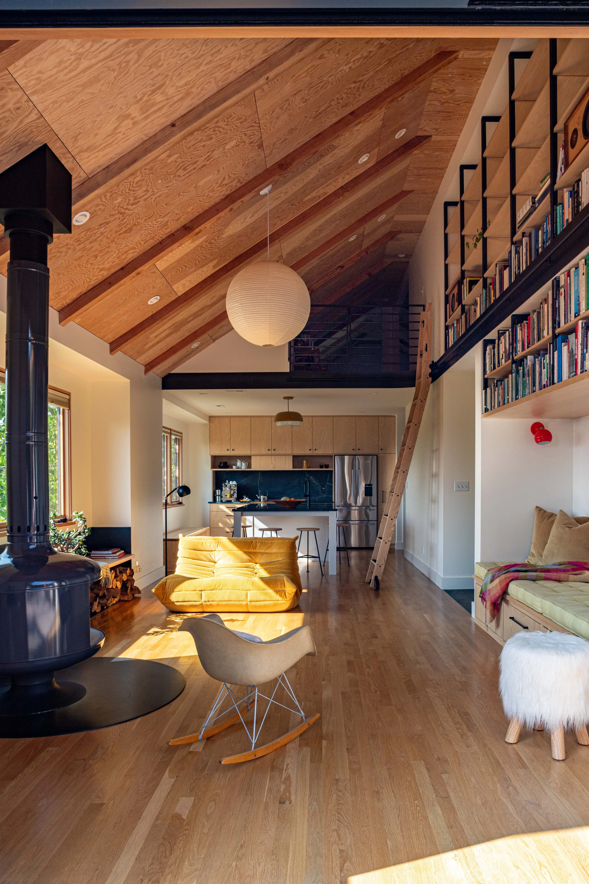 Piano Nobile residential interior with exposed wood ceiling, loft, built-in shelving, and open kitchen.