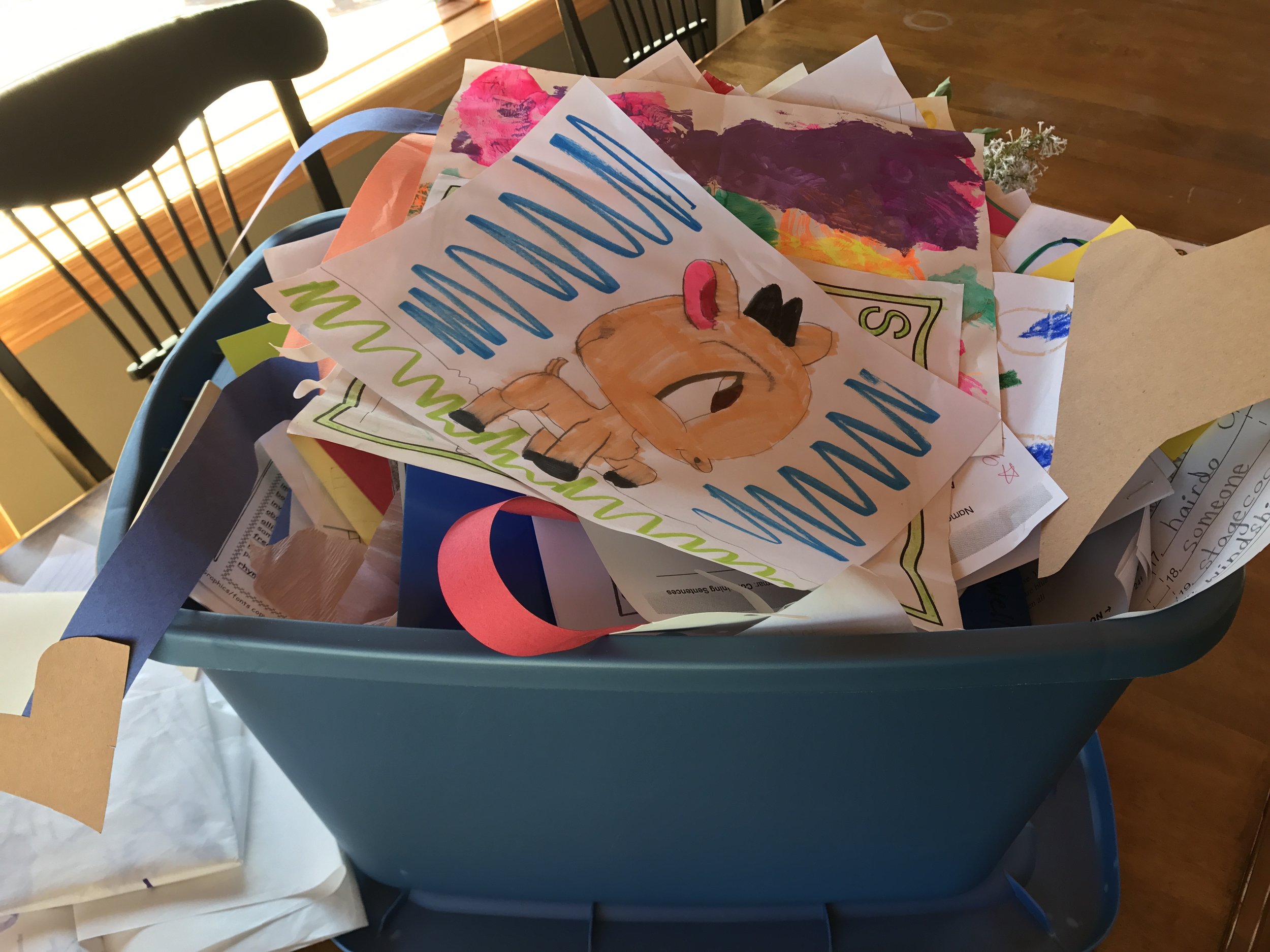 Collect school projects, artwork, and drawings in a bin throughout the year.