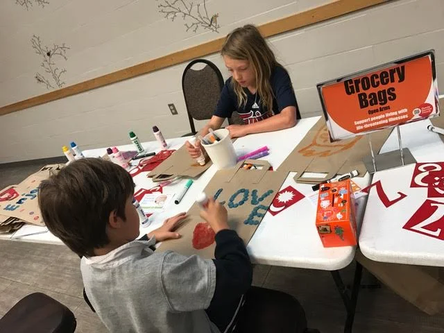 Brothers worked together to decorate grocery bags which will hold items for the local food pantry.