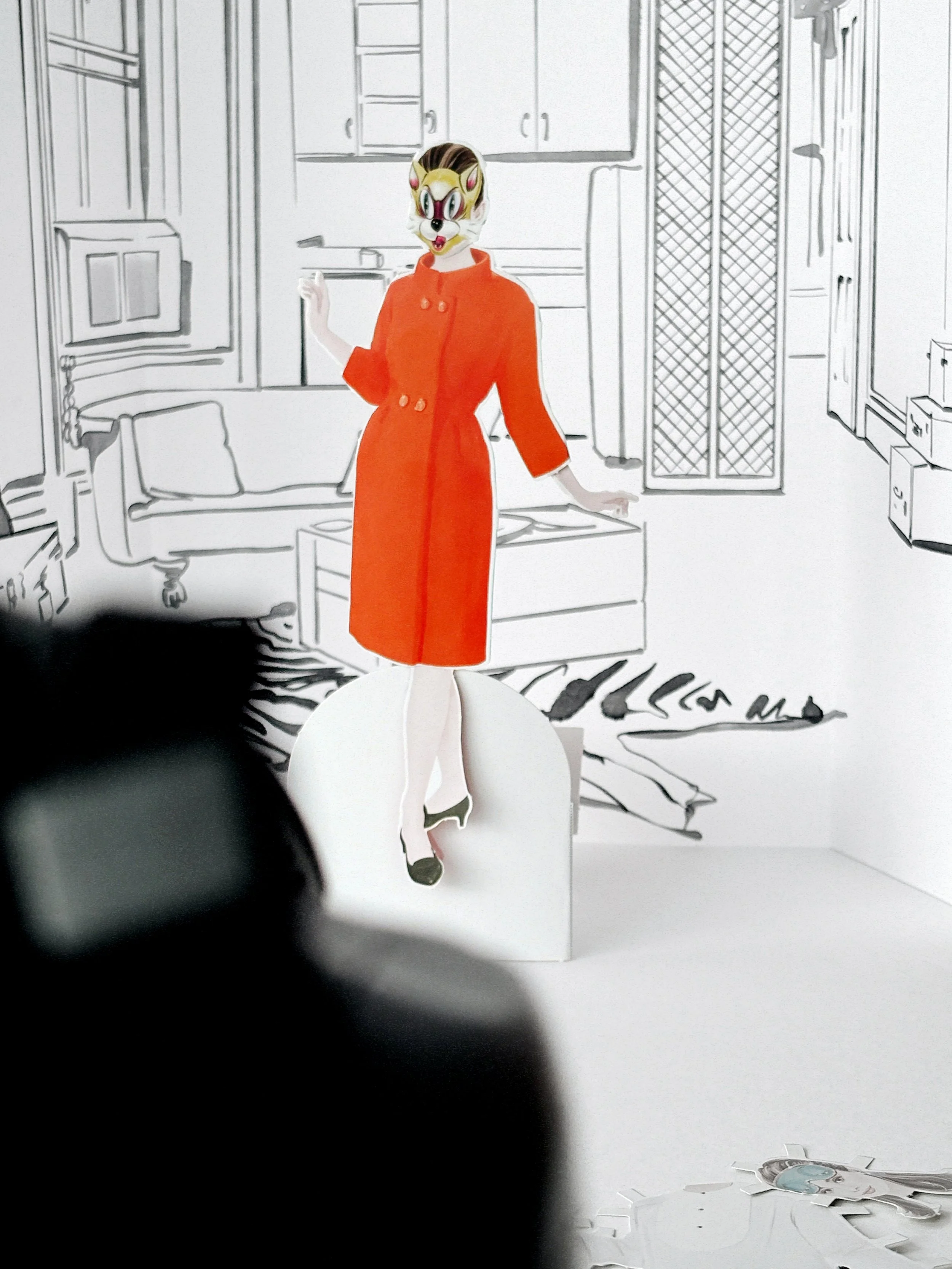 Assembled Audrey Hepburn paper doll. Dressed in the orange coat and cat mask from 'Breakfast at Tiffany's.'