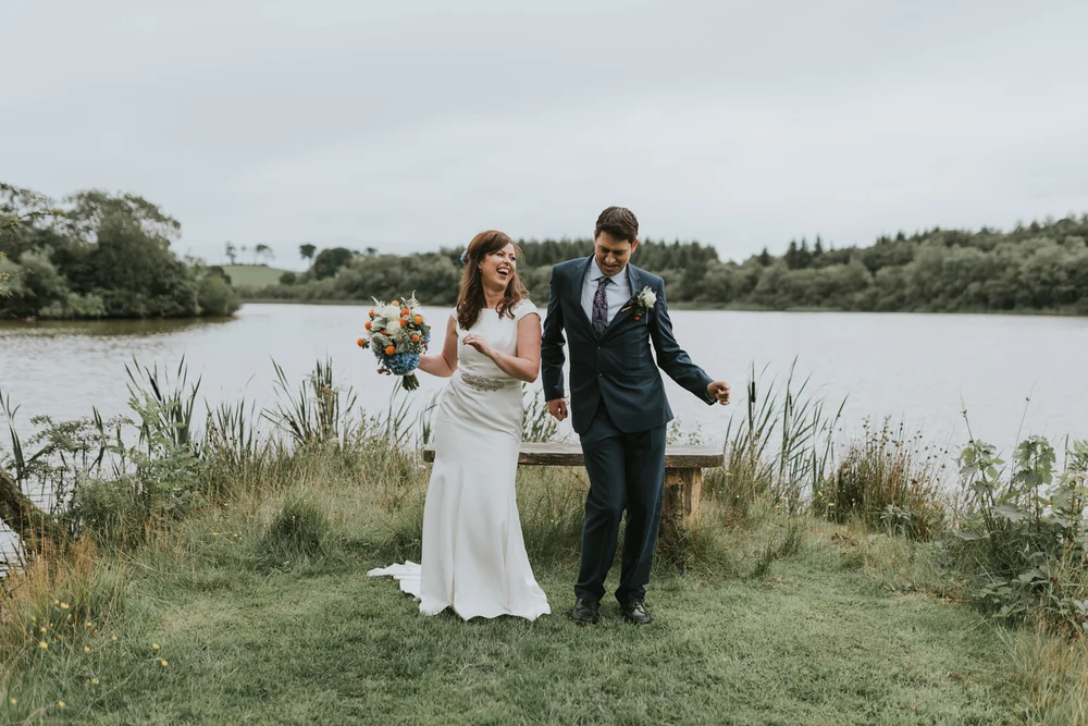 Hannah and Julian laughing together beside the lake at Lissanoure Castle