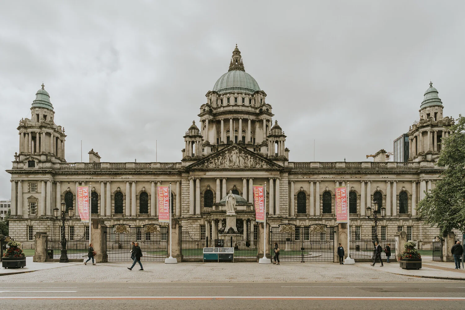 The front of Belfast City Hall in Donegall Square with its green copper dome and corner towers under a grey sky