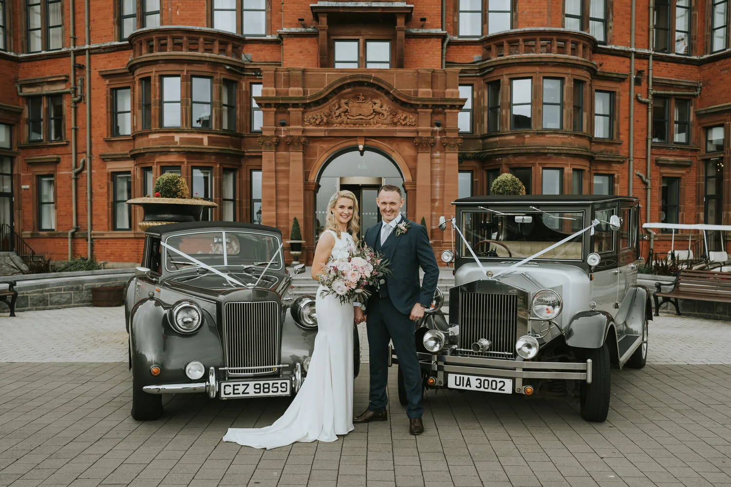 Bride and groom with vintage wedding cars at Slieve Donard Resort and Spa