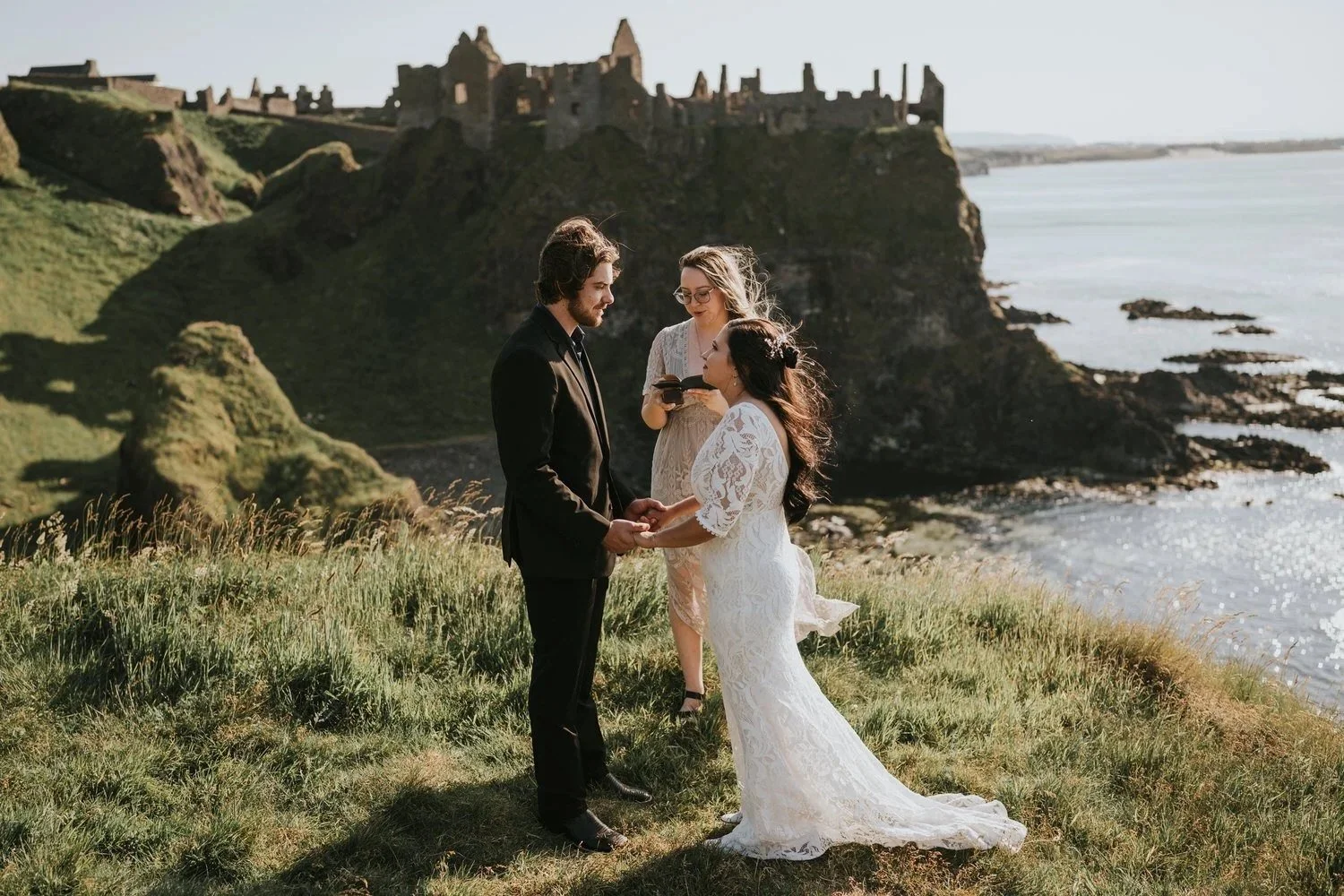 Couple exchanging vows during an elopement ceremony at Dunluce Castle on the Antrim Coast in Northern Ireland, photographed by Pure Photo NI