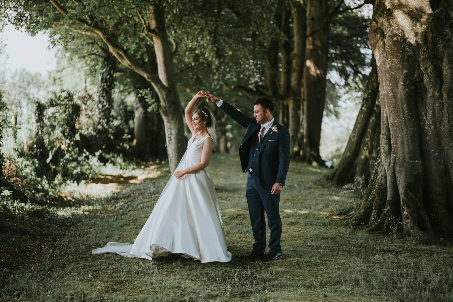 Ashleigh and Nathan's wedding, with the bride twirling beneath old beech trees at Corick House