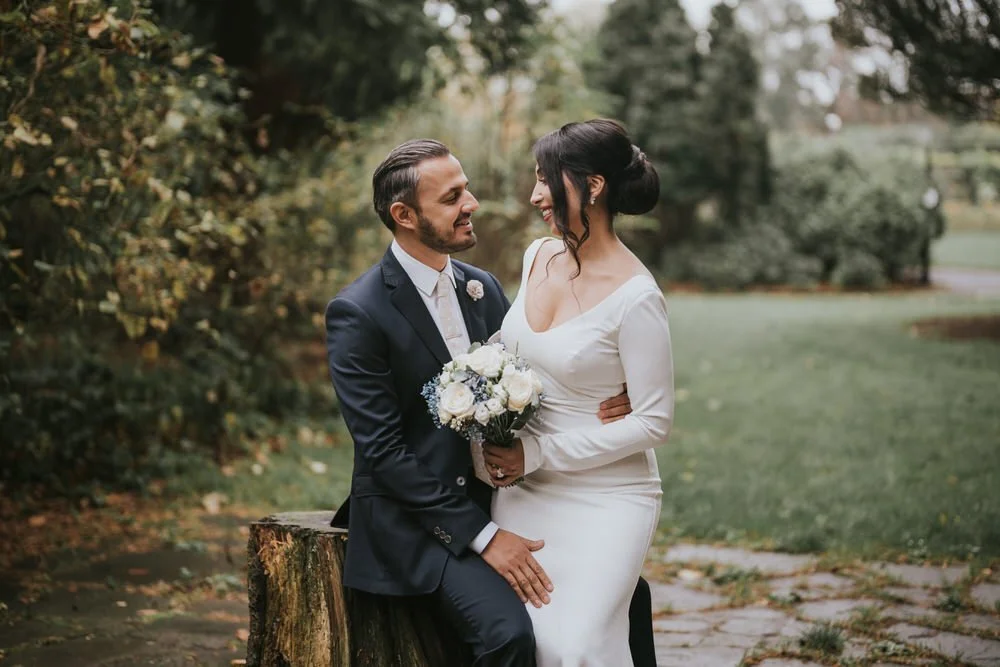 Groom smiling at his bride as she holds her bouquet on their Belfast wedding day