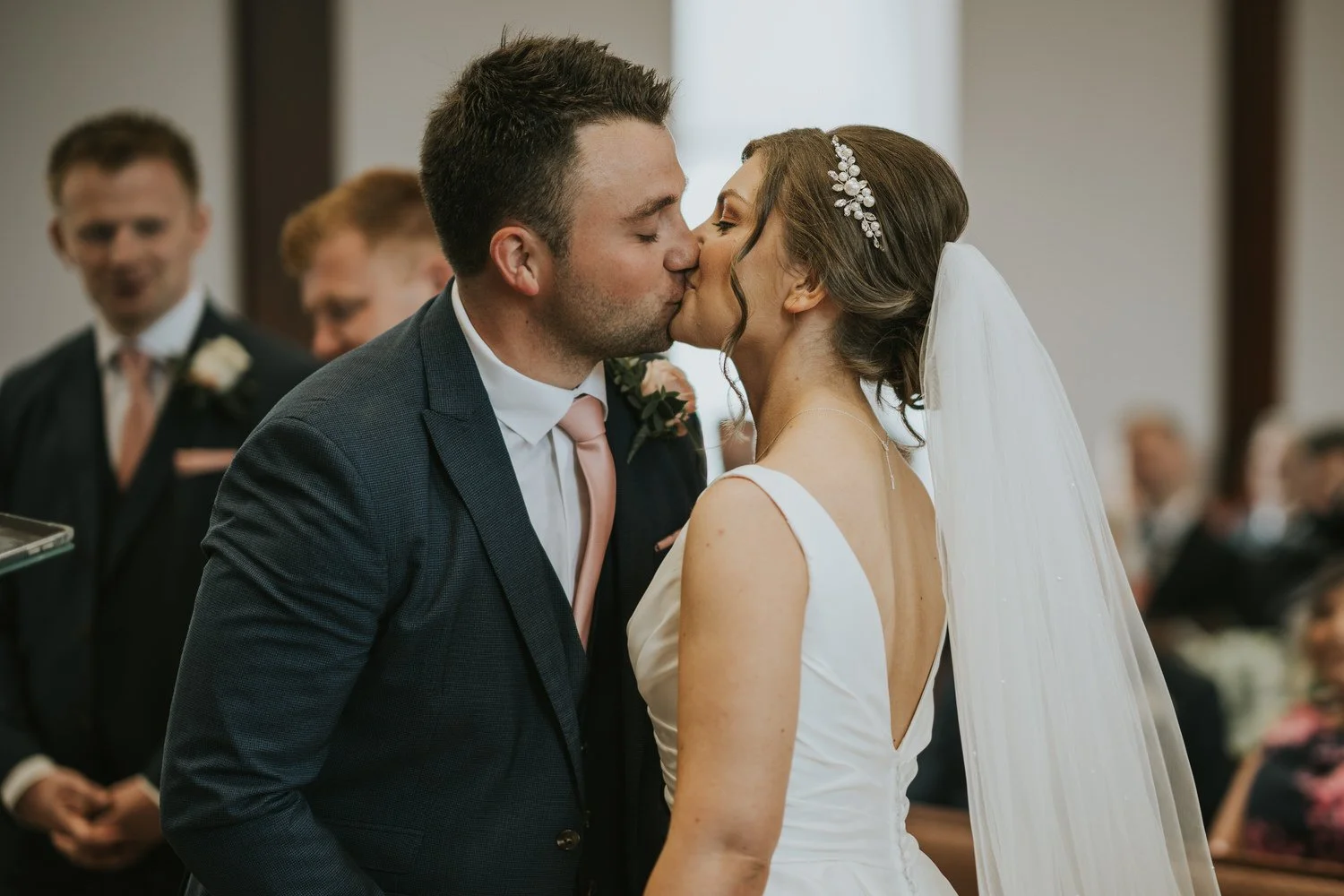 Bride and groom sharing a kiss at their church ceremony