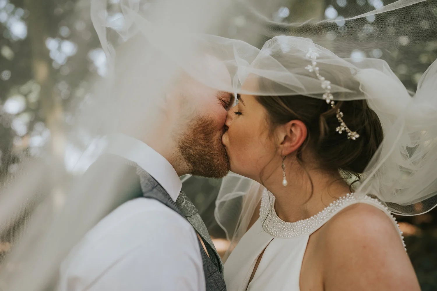 Louise and Lee's wedding at Tullyveery House, the couple kissing as the veil drifts around them
