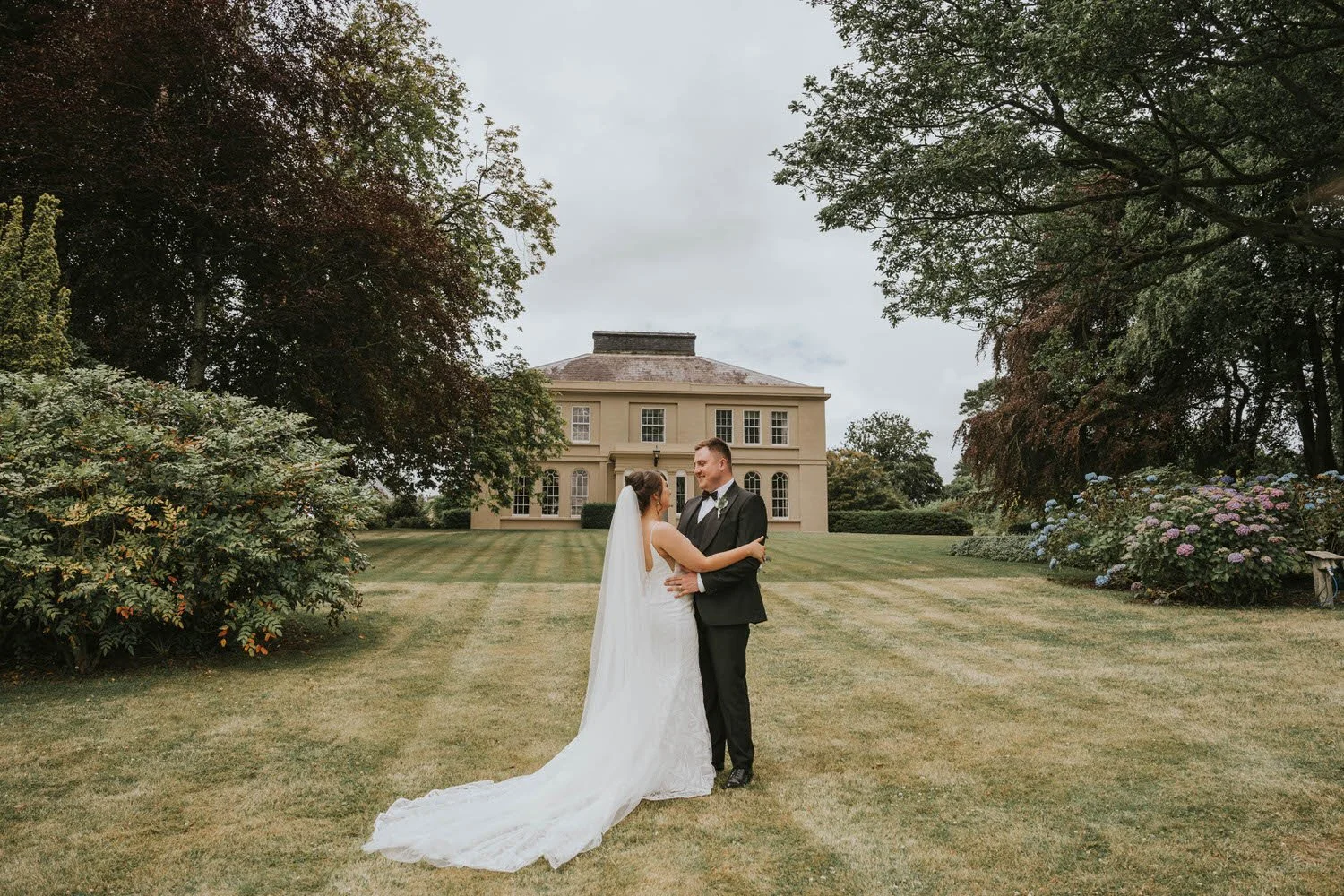 Bride and groom standing on the lawn in front of Tullyveery House