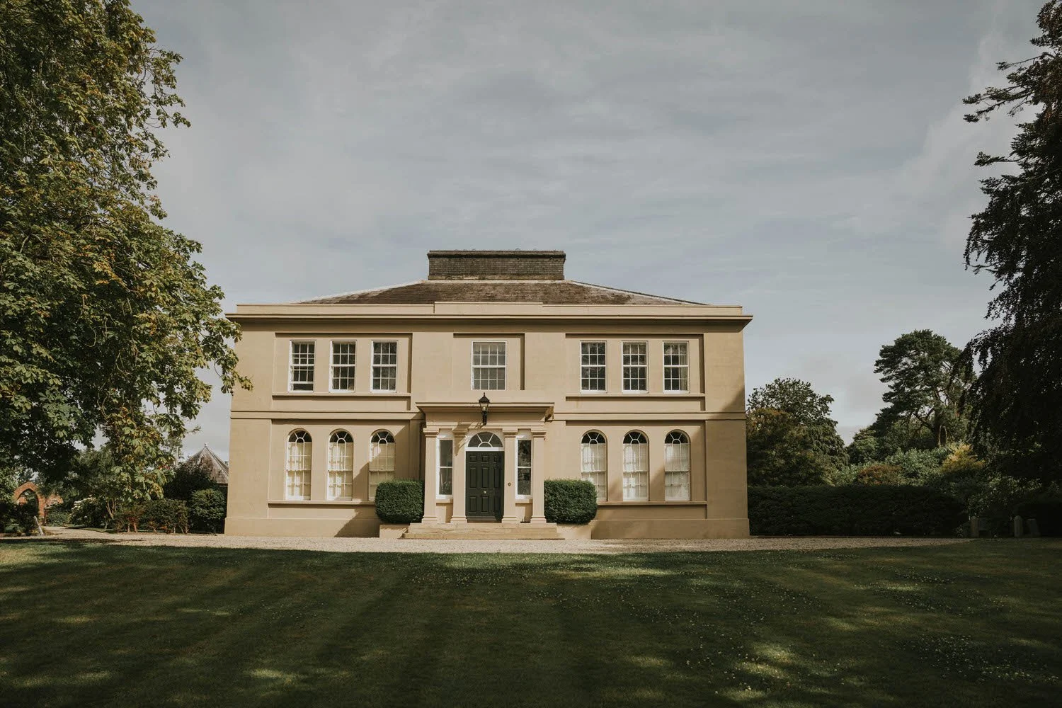Front of the Georgian country house at Tullyveery House near Killyleagh, seen across a mown lawn under a soft sky