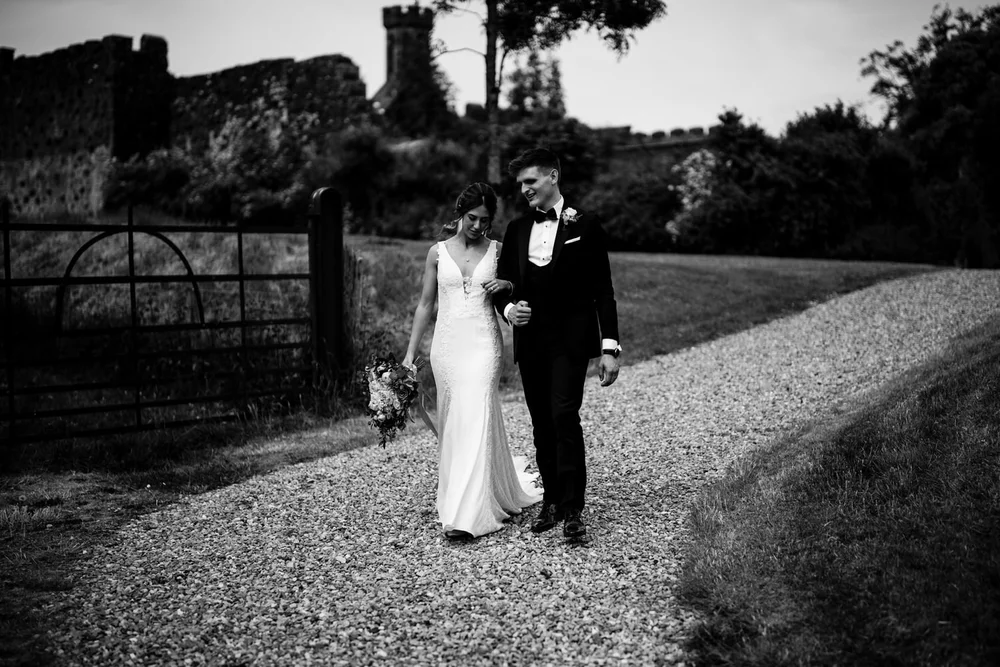 Black and white photo of Hannah and Mark walking along the gravel path at Lissanoure Castle
