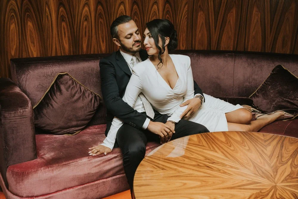 Bride and groom relaxing on a velvet sofa inside The Merchant Hotel, Belfast