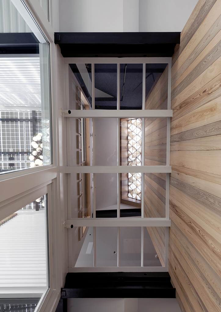Starphire structural glass floor at entry hall with view to north facing skylight above with walls clad in 100+ year old reclaimed sinker cypress.