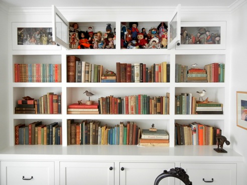In the library, books, artifacts and a doll collection share the shelves.