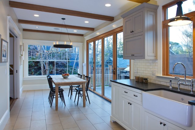Large accordion doors provide access to the deck. Limestone ceramic tile, soapstone countertops and natural fir trims complement the mushroom and off-white tones of the cabinets.