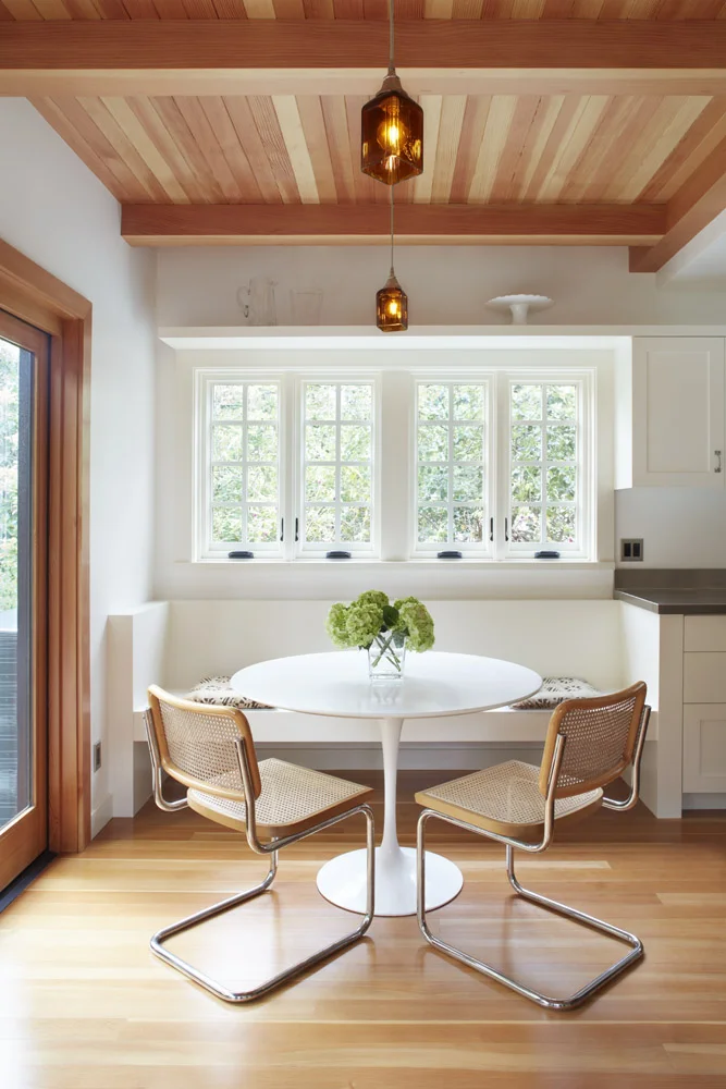 Large openings allow the kitchen to be flooded with natural light. Fir ceiling and floors counterbalance the brightness of the space, complemented by the contrast of jet gray and chalky whites. In other rooms the antique mahogany panelling cohabits with crisp concrete and hot rolled steel details. Custom sconces by Kip Mesirow adorn the walls throughout the house. Photo credit: Muffy Kibbey. Construction: Jetton Construction. Architect: Denise Hall Montgomery.