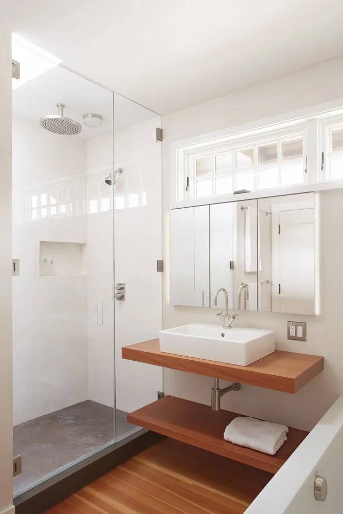 concrete shower pan, backlit recessed medicine cabinet, floating mahogany shelves vanity