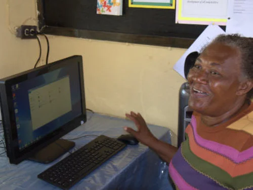 School Principal, Ms Jones, is delighted to receive the new computer equipment.