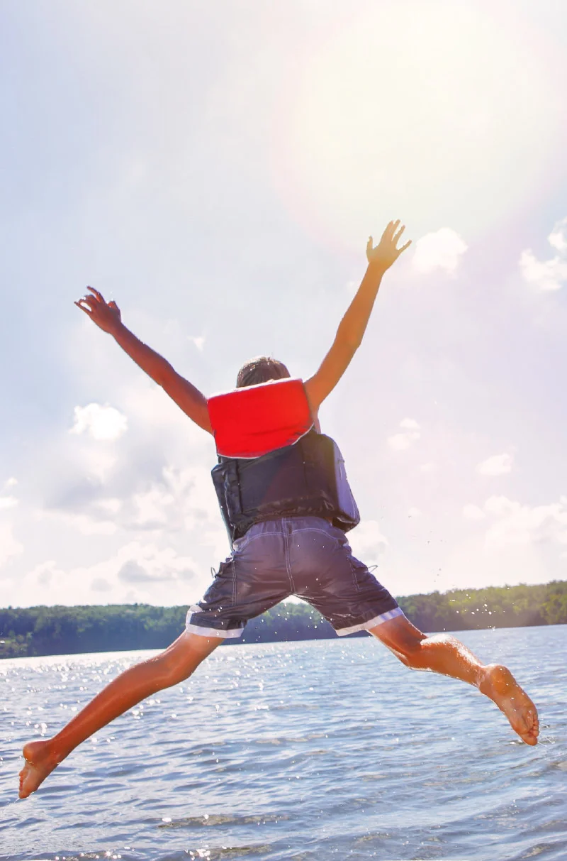 Boy jumping off boat