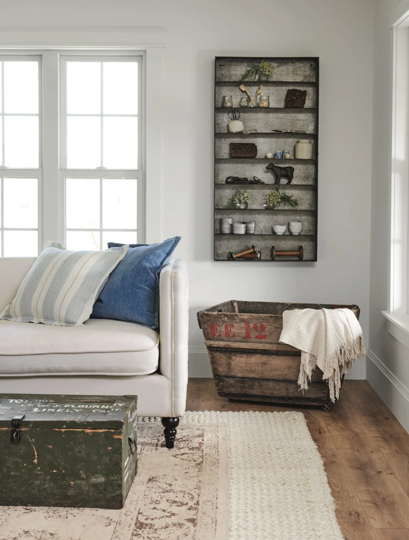 Farmhouse+living+room+with+metal+spice+shelf+wall+art+and+vintage+army+trunk+coffee+table+with+tufted+couches+and+vintage+champagne+crate+|+#farmhousestyle+#farmhouse copy.jpg
