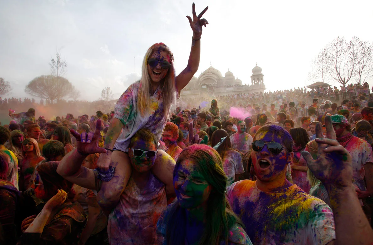 Brinley Brown dances on Josh Emerson's shoulders during the Holi Festival of Colors at the Krishna Temple in Spanish Fork on Saturday, March 24, 2012.