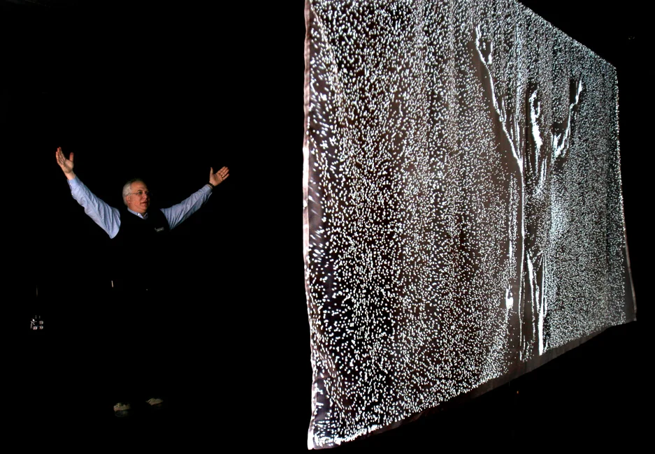 Andy Munitz raises his arms and watches a digital reflection of himself form as part of Daniel Rozin's interactive artwork in the New Frontier during the Sundance Film Festival.