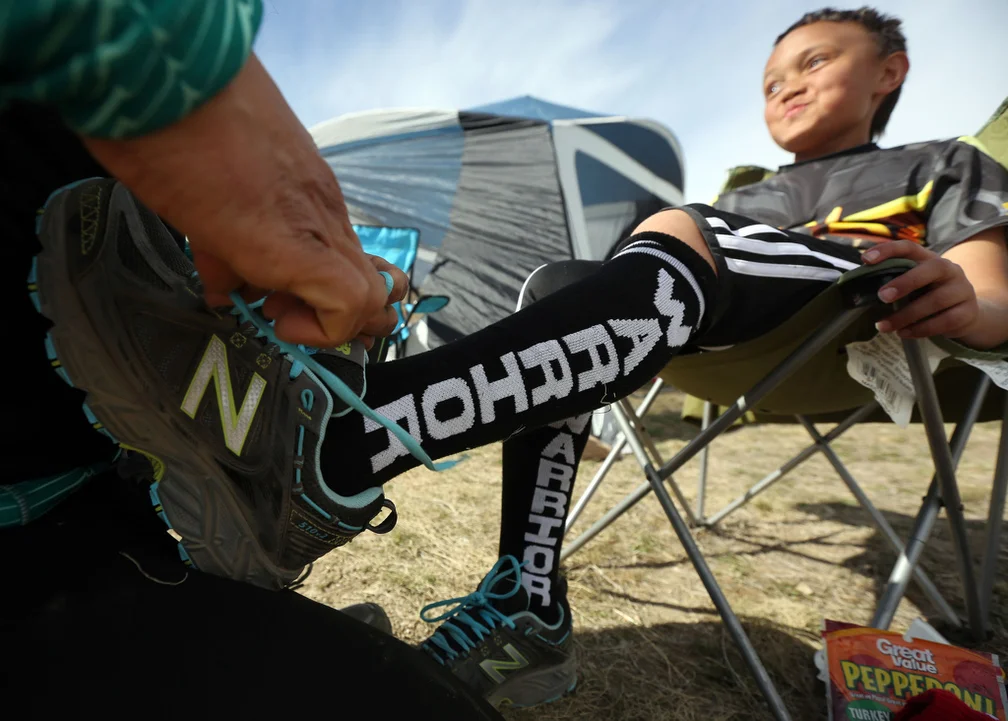  Lota Ward, 8, gets new socks and shoes at mile 28 of the 50 mile Buffalo Run on Antelope Island on Saturday, March 21, 2015. Ward's full name is Lotatoa, which means "our warrior" in his mother's native Samoan language. Ward is also battling a terat