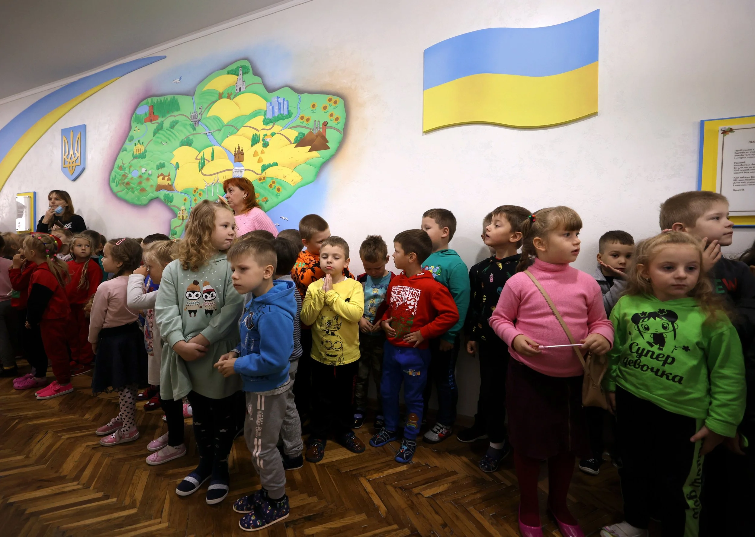  Artem Karnaukh, in yellow, holds his hands in prayer before all the students pray together on his last day in kindergarten before moving to the United States at Chervonohrad Kindergarten No. 13, in Chervonohrad, Ukraine, on Monday, Sept. 19, 2022. 