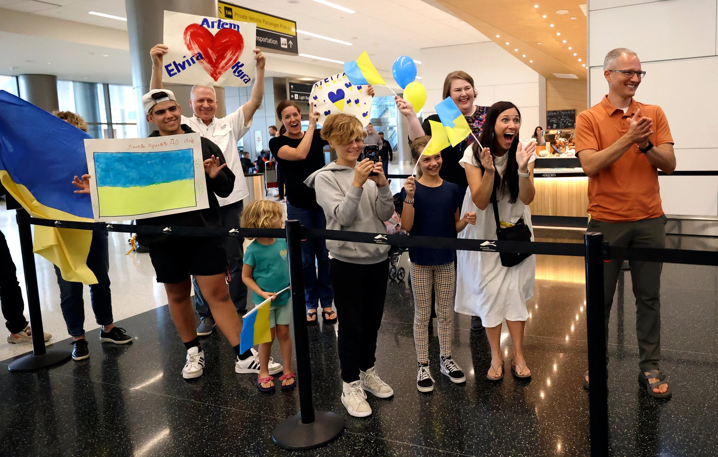  WelcomeNST team members cheer as Ukrainian refugees Elvira Karnaukh, Kira Karnaukh and Artem Karnaukh arrive at the Salt Lake City International Airport in Salt Lake City on Wednesday Sept. 21, 2022. NST is an acronym for neighborhood support teams,